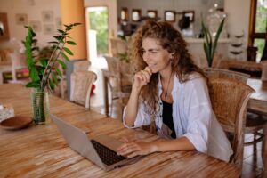 A smiling woman using a laptop.